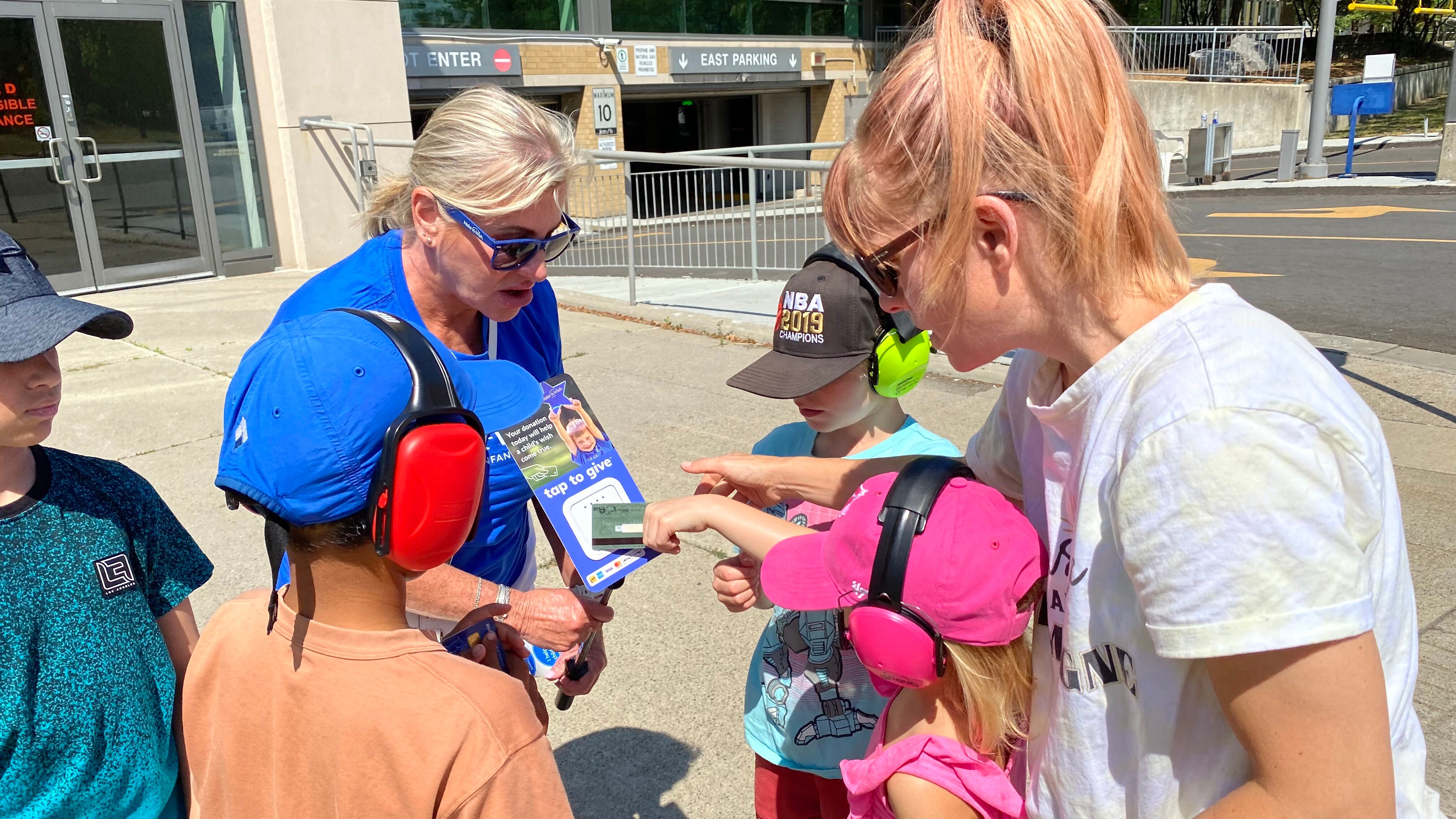 A Make-a-Wish volunteers accepts a donation from race fans